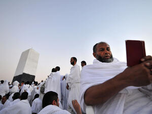 A Muslim pilgrim reads the Quran on top of Mount Arafat in Mecca ahead of the Hajj pilgrimage. (AFP/File)