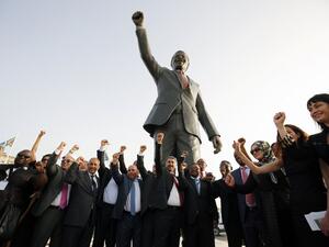 Palestinian and South African officials pose in front of a giant statue of Nelson Mandela during its inauguration ceremony in the West Bank city of Ramallah on April 26, 2016. (AFP/Abbas Momani)
