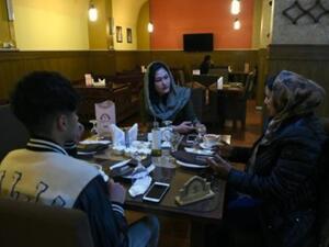 رجال ونساء يتناولون الشاي في مطعم في كابول
