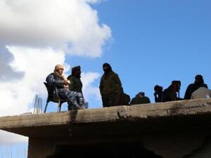 مقاتلون من قوات سوريا الديموقراطية فوق سطح في بلدة الباغوز الفوقاني في ريف دير الزرو في شرق سوريا
