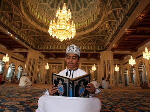 A boy reads the Qur'an inside the Sultan Qaboos Grand Mosque in Oman's capital city Muscat.  (AFP/Mohammed Mahjoub) 