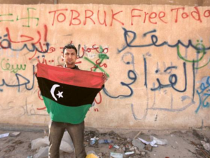 An opposition protester hold a Libyan flag in the eastern city of Tobruk in 2011. (AFP/File)