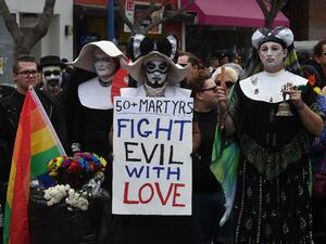Participants in Los Angeles' gay pride parade show their solidarity for the victims of a mass shooting - the largest in U.S. history - that killed at least 50 people at a popular gay nightclub in Orlando, Florida.  (AFP/Mark Ralston)