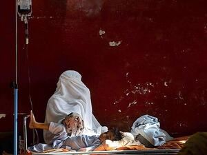 A mother sits alongside her son, a thalassemia patient, as he receives blood in Peshawar, Pakistan on Dec. 4, 2014. (AFP/File)