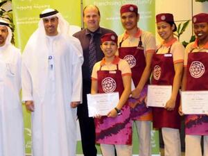 Rahma Bin Mohammad Al Shamsi, the Retail Sales Manager of Emarat, honors the four employees