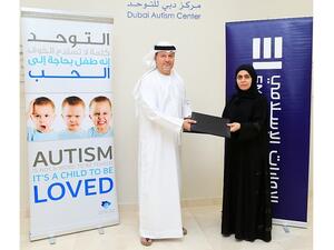 Awatif Al Harmoodi, General Manager, Operational Quality & Processes at Emirates Islamic, presenting the cheque to Mr. Mohammad Amin Al-Emadi, Board Member at Dubai Autism Center.