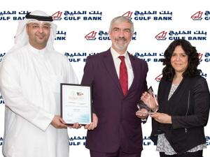 Laila Al-Qatami and Ahmed Al-Fassam receiving the award on behalf of Gulf Bank