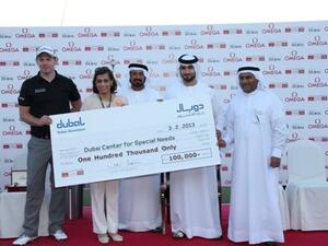 DDC champion Stephen Gallacher with Dr. Maushid from Dubai Center for Special Needs receiving the cheque from Mohamed Yahya