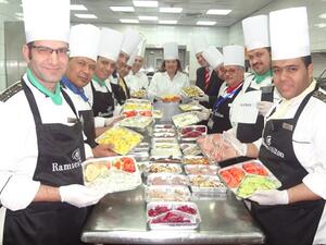 Soha El Torgoman, Ramses Hilton General manager with the kitchen brigade while preparing the packed meals ready for distribution.