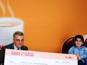 David Rodgers, General Manager of Dunkin’ Donuts, presenting a cheque to Sharjah charity