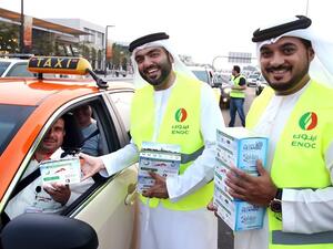 ENOC employees distributing ‘Iftar Packs’ comprising dates and water to motorists at red lights