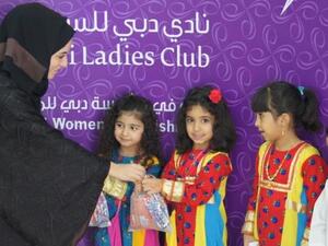 Eman Al Mansoori, Events Manager at Dubai Ladies Club gives children Hag Al Leilah goody bags