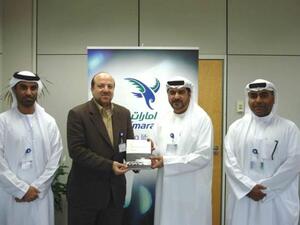 Abdulrahman Qassim Al Ali, Commercial Sales Manager at Emarat, receiving the book from its author in the presence of Salem Bin Suloom and Nassar bin Nassar