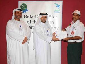 Abdulla Hassan Al Noman, Manager, Retail Sales Operations at Emarat honoring one of the employees