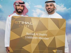 عضو برنامج ضيف الاتحاد رقم خمسة ملايين، راشد الشحي (يسار) يتلقى التهنئة من قبل ياسر اليوسف، المدير الإداري لبرنامج ضيف الاتحاد.