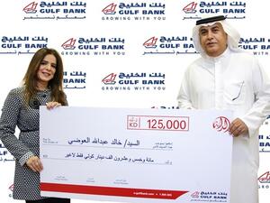 Mr. Khaled Al-Awadhi, Al Danah’s KD 125,000 winner, receiving his prize from Mansouriya Senior Branch Manager Mrs. Nawar Al-Yaseen
