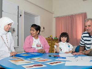 الطفلة هيا النعيمي مع الاختصاصيين بمركز تطوير الطفل