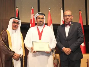 راشد الأنصاري، مدير عام شركة "الأنصاري للصرافة" أثناء تسلمه الدرع التكريمي
