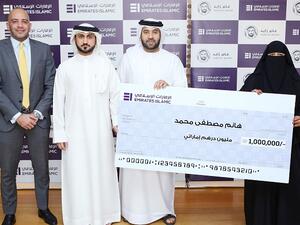 Kunooz Winner Ms. Hanim Mustafa Mohamed receiving the Dh1 million Grand Prize from Emirates Islamic