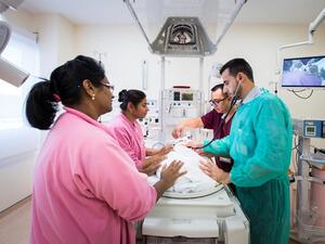 إحدى كوادر الفرق متعددة التخصصات الطبية ترعى أحد الأطفال حديثي الولادة في توسعة وحدة العناية المركزة لحديثي الولادة