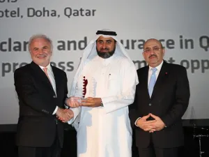 المهندس جاسم تلفت، المدير التنفيذي للمجموعة في الإدارة العامة للمشاريع الرئيسية والإدارة العامة للمرافق في مؤسسة قطر (وسط) يتسلم الجائزة من قبل السيد إدموند اوسوليفان، رئيس مجلس إدارة ميد (يسار) بحضور السيد جبرا رجا غندور، المدير التنفيذي لبنك قطر الدولي
