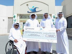 Rashed Al Ansari, General Manager of Al Ansari Exchange giving the donation to Thani Juma Berregad, Chairman of Dubai Club for people of Determination.
