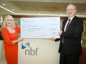 Vince Cook awarding 100,000 AED cheque to Mission to Seafarers.