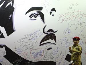 Qataris write on a wall bearing a portrait of Sheikh Tamim bin Hamad Al-Thani that has become a symbol of resistance during the Gulf diplomatic crisis. (Karim Jaafar/ AFP)