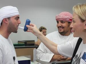 موظفا الشركة محمد حسين وصالح الزيتاوي أثناء قيام الممرضة ناتالي أدزهافي باجراء اختبار فحص أول أكسيد الكربون لهما في المقر الرئيسي للاتحاد للطيران في إطار الحملة التي تنظمها الشركة لموظفيها لمكافحة التدخين