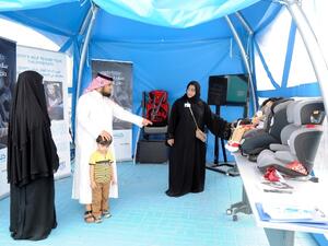 Kulluna volunteers explain importance of child car seat to visitors