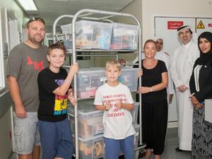 الطفل "فين" مع الألعاب والهدايا التي جمعها لمرضى السرطان الأطفال في مستشفى حمد العام