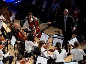 الموسيقار جيوفاني بازيني، عازف الفيولا الرئيسي في أوركسترا قطر الفلهارمونية، يقود الأوركسترا المشتركة