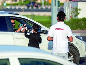 Ooredoo volunteers gift water and dates to a motorist at Aspire Zone. (The Peninsula)