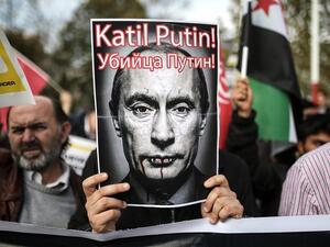 A protester holds a poster depicting Russian President Vladimir Putin and reading “Putin, killer!” during a demonstration in Istanbul, on November 27, 2015. (AFP/ Cagdas Erdogan)