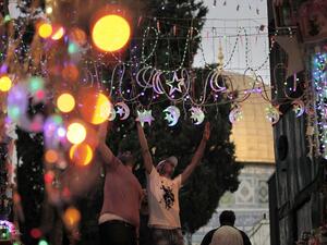 Men adorn Jerusalem's streets with Ramadan lights near the entrance of Al-Aqsa Mosque.  (AFP/File)