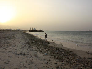 Girl standing at a polluted beach at sunset at the coast of Oman. (Shutterstock/ File)