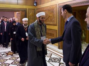 بشار الاسد يصافح الفريق الديني