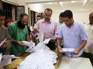 موظفون يقومون بفرز الأصوات بعد نهاية المرحلة الأولى من الانتخابات في لجنة انتخابية بمحافظة الجيزة
