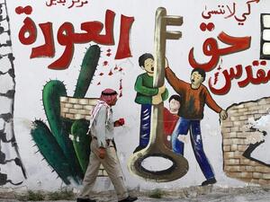 Palestinian man walks past a mural in the West Bank city of Jenin. The Arabic reads: "So that we don't forget the sacred right to return.(AFP/Saif Dahlah)