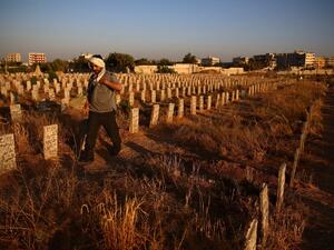A Syrian man visits the graves of loved ones at a cemetery in the rebel-held area of Douma, east of the capital Damascus, on July 19, 2015. (AFP/Abd Doumany) 