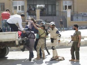 أفراد من "جيش الفتح" والدفاع المدني يساعدون مدنيين على الفرار من مدينة أريحا في شمال غرب سوريا بعد أن سيطر تحالف من قوات المعارضة السورية عليها يوم الخميس
