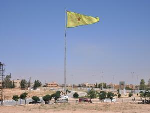 علم وحدات حماية الشعب الكردية مرفوعا في بلدة تل ابيض السورية
