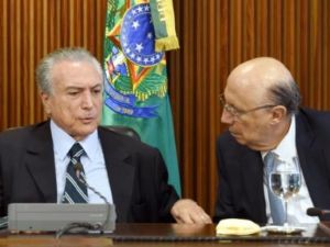 الرئيس المؤقت ميشال تامر (يسار) يتحدث الى وزير الاقتصاد انريكي ميريليس في اول اجتماع حكومي في قصر بلانالتو ببرازيليا
