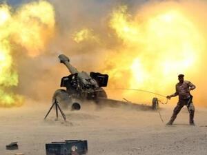 أحد أفراد قوات الأمن العراقية يطلق قذيفة مدفعية خلال الاشتباكات مع مقاتلي تنظيم الدولة الإسلامية بالقرب من الفلوجة
