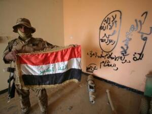 مقاتل عراقي موال للحكومة يحمل العلم الوطني داخل مقر لتنظيم الدولة خلال عملية تطهير حي الضباط في الفلوجة

