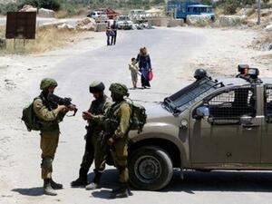 جنود من الجيش الاسرائيلي يقفون عند مدخل مدينة يطا اثناء حصارها يوم الخميس

