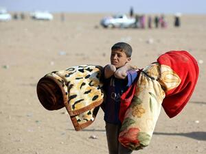 An Iraqi refugee boy fleeing Mosul (AFP/File)