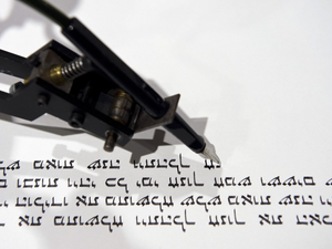 A robotic pen writes a passage of the Torah in an instillation at the Jewish Museum in Berlin.  (AFP/John MacDougall)