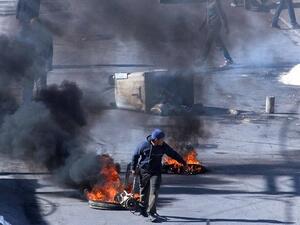 Tunisian demonstrators block the road with burning tires in the central city of Kasserine during protests, on 21 January, 2016, triggered by the death of an unemployed man. (AFP/ Mohamed Khalil)