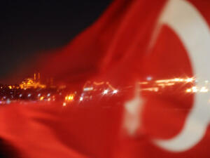 The Turkish flag is seen in front of Istanbul's skyline.  The Turkish government's decision to demolish an Izmir football stadium - once the gathering place of a diverse array of ethnic groups - recalls frightening memories of ethnic cleansing at the hands of the Ottoman Empire a century ago.  (AFP/Bulent Kilic)